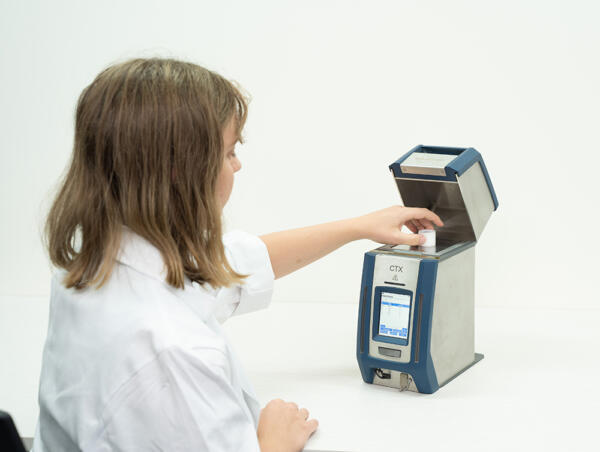 Person putting sample cup into a portable XRF