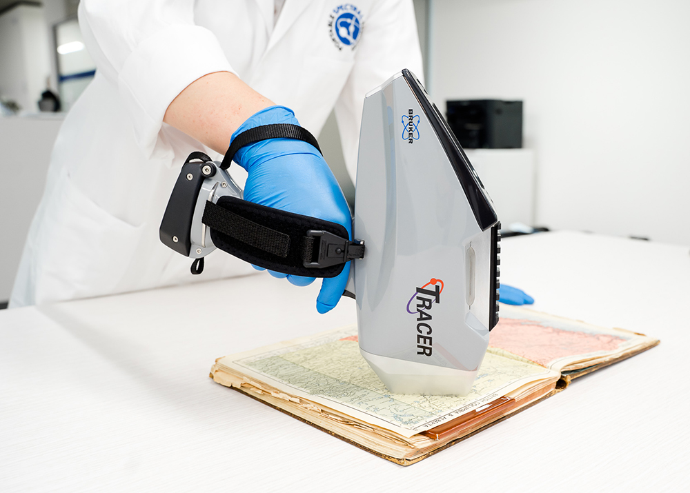 A portable XRF analysing the inside page of a book.